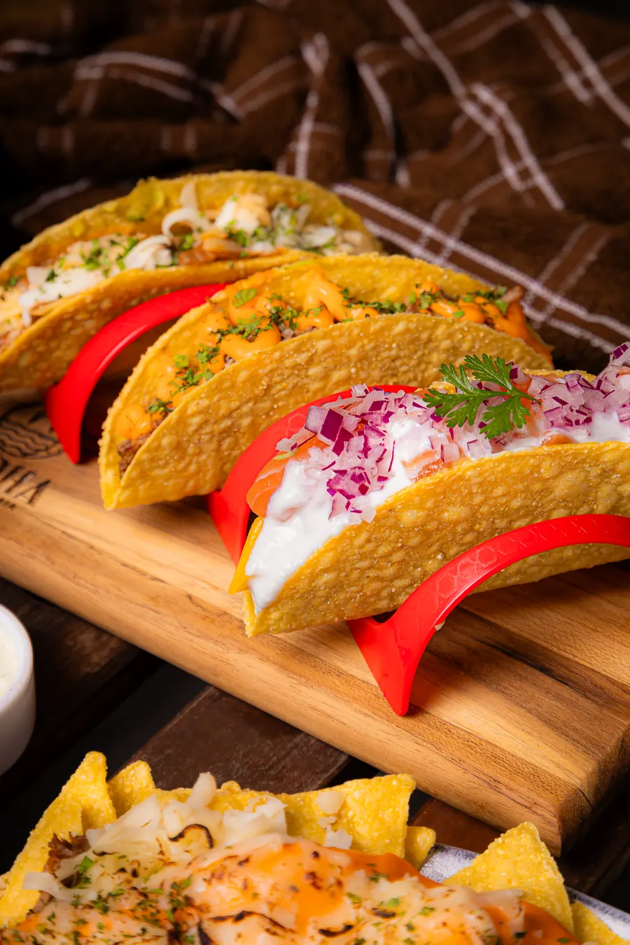 Tacos crocantes recheados em suporte de madeira